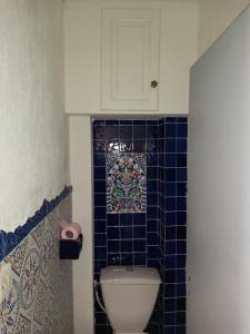 ein Bad mit einem WC und einer blau gefliesten Wand in der Unterkunft Appartement vue mer in Narbonne-Plage