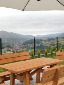 a wooden picnic table with two chairs and a view at Domek na Słonej in Szczawnica