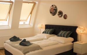 um quarto com uma cama com duas almofadas e duas janelas em Wonderful Penthouse with stunning Terrace DG1 QS12 em Viena