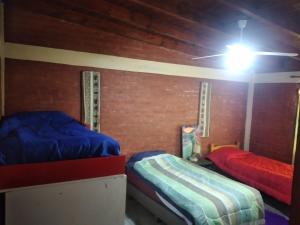 um quarto com 2 camas e uma ventoinha de tecto em CASABLANCA em El Ceibal
