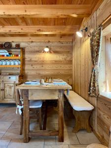 - une salle à manger en bois avec une table et des chaises dans l'établissement Baita di Charme Le Petit Chanton - CIR 0016, à Gaby