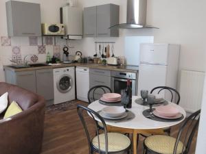 uma cozinha com uma mesa e cadeiras numa cozinha em La Lauzeta em Sarlat-la-Canéda