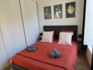 um quarto com uma cama vermelha e 2 almofadas em La Lauzeta em Sarlat-la-Canéda