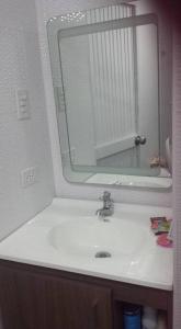 ein Badezimmer mit einem weißen Waschbecken und einem Spiegel in der Unterkunft Fantástica cartagena accesible para todos in Cartagena de Indias