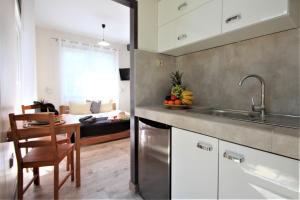 a kitchen with a sink and a table in a room at Apart Studio Rambiert in Swarzewo