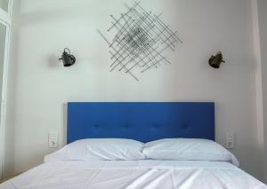 a bed with a blue headboard and two lights above it at La chica de la perla in Torremolinos