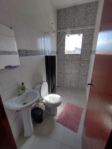 La salle de bains est pourvue de toilettes, d'un lavabo et d'une douche. dans l'établissement Apartamento da Rosi, à Resende