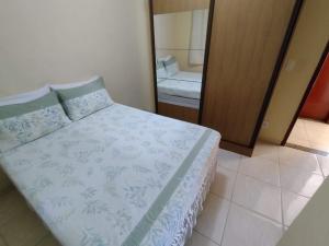 a bedroom with a bed and a large mirror at Apartamento da Rosi in Resende