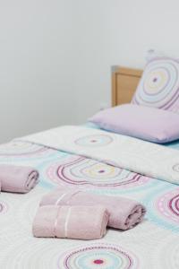 two beds with pink and white towels on them at Apartman Sunčica in Lukavica