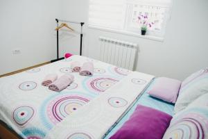 Una cama con almohadas rosas encima. en Apartman Sunčica, en Lukavica