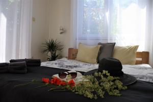 a bed with a hat and sunglasses and flowers on it at Apart Studio Rambiert in Swarzewo