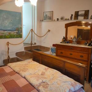 a bedroom with a bed and a dresser and a mirror at La Nicchia di Franco in Montignoso