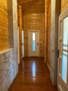 a hallway with wooden walls and a white door at Cabana DEBORAH , Fardea lacu Surduc in Fîrdea