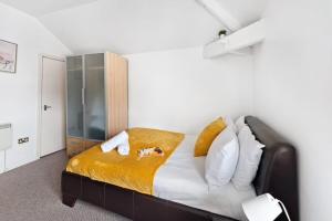 a bedroom with a large bed with white and yellow sheets at Heart of City Centre - Newcastle in Newcastle upon Tyne