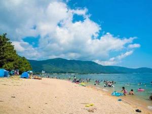 琵琶湖畔徒步0分の宿 في أوتسو: مجموعة من الناس على شاطئ قريب من الماء