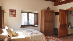 1 dormitorio con cama y ventana en Casa Rural Nevada, en Horcadas