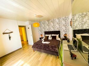 a bedroom with a bed and a desk with a laptop at Giulia House Fécamp - Seaside Escape, Modern & Cozy in Fécamp