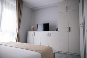 a bedroom with a bed and white cabinets and a tv at BlueSky Premium Apartment Baile Felix in Baile Felix