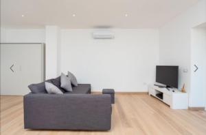 a living room with a black couch and a tv at Elegant Country House - Tenuta Piredu in Monti
