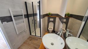 a bathroom with a toilet and a sink and a shower at La Parent'aise in Parentis-en-Born