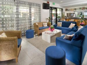 リッチョーネにあるHotel La Cappuccinaのリビングルーム(青いソファ、椅子付)
