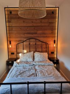 sypialnia z dużym łóżkiem z drewnianym zagłówkiem w obiekcie Komfortowy apartament przy lesie w Wejherowie