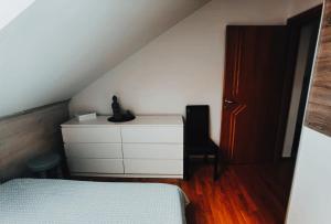a bedroom with a bed and a dresser and a chair at Apartman Jurak in Zaprešić