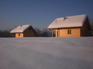 two buildings with snow on top of them at Holiday Homes Eko Klanac in Rakovica