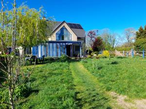 una casa en un campo con un camino que conduce a ella en Le chant des oiseaux, en Montmartin-sur-Mer