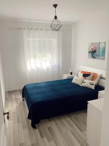 um quarto com uma cama grande e um cobertor azul em Mima House Al em Aveiro