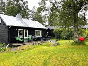 una casa nera con tavolo e sedie in cortile di Holiday home SKÖVDE a Skövde