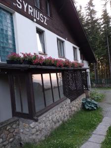 a building with flowers on the side of it at Pensjonat Syriusz in Karpacz