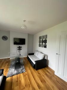 a living room with a couch and a flat screen tv at Cosy home near NEC, BHX Bullring & Solihull in Birmingham