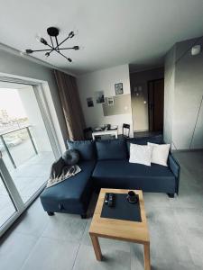 a living room with a blue couch and a table at Apartament Husarska in Rumia