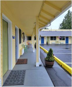 un couloir vide d'un bâtiment avec colonnes et plantes dans l'établissement Buckley Inn, à Buckley