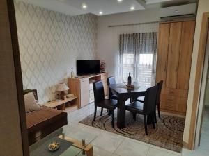 een woonkamer met een tafel, stoelen en een televisie bij Zlatibor Hills Nature in Zlatibor
