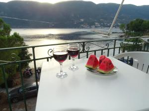 a table with two glasses of wine and watermelon at VASILIKI ROYAL STOUDIOS in Vasiliki