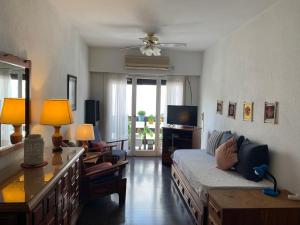 a living room with a bed and a television at Lindo apartamento cerca del mar, Pinamar in Pinamar