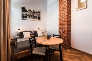 a room with a table and a bed and a table and chairs at Apartmány Krmanova in Košice