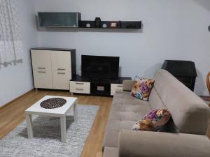 a living room with a couch and a tv at Holiday Home Adna in Bihać