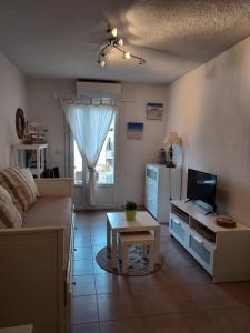 salon z łóżkiem, stołem i telewizorem w obiekcie Sanary soleil et douceur IV w mieście Sanary-sur-Mer