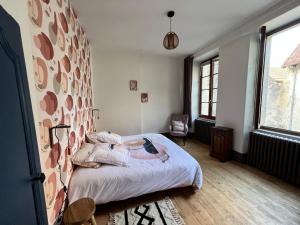 um quarto com uma cama e uma grande parede em Maison dans quartier historique : La Grenouille em Avallon