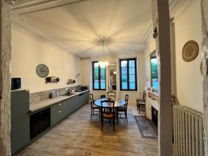 Maison dans quartier historique : La Grenouille في أفالون: مطبخ وغرفة طعام مع طاولة وكراسي