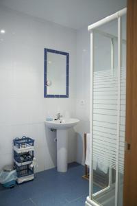 Baño blanco con lavabo y espejo en Quintana 23 en Suances