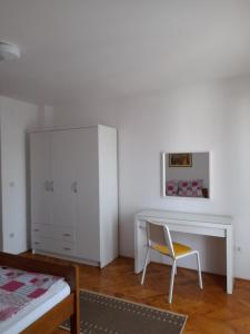 ein Schlafzimmer mit einem weißen Schreibtisch und einem Stuhl in der Unterkunft Apartment Gotovina Biograd na Moru in Biograd na Moru