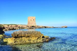 a lighthouse on a rocky island in the water at B&B Torre Pozzillo in Cinisi
