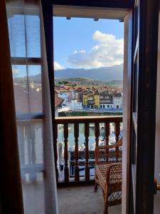 a room with a view of a harbor from a balcony at Apartamentos Calle Mayor 23 Llanes in Llanes