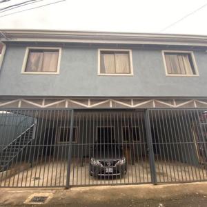 a house with a car parked inside of a gate at Apartamentos Cielo #1, Airport Juan Santamaría in Alajuela