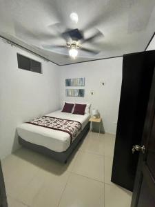 a bedroom with a bed with a ceiling fan at Apartamentos Cielo #1, Airport Juan Santamaría in Alajuela