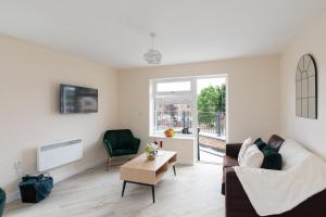 a living room with a couch and a table at homely - North London Apartments Wembley in Harrow on the Hill